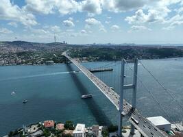 Istambul bósforo ponte e cidade Horizonte dentro fundo com turco bandeira às lindo pôr do sol, aéreo deslizar órbita e rastreamento tiro foto