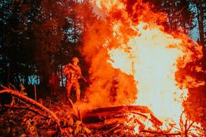 soldado dentro açao às noite dentro a floresta área. noite Tempo militares missão pulando sobre fogo foto