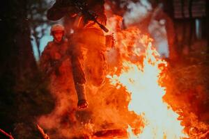 soldado dentro açao às noite dentro a floresta área. noite Tempo militares missão pulando sobre fogo foto