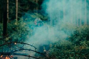 uma soldado lutas dentro uma floresta de guerra área cercado de fogo foto