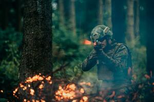 uma soldado lutas dentro uma floresta de guerra área cercado de fogo foto