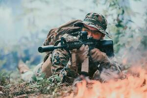 uma soldado lutas dentro uma floresta de guerra área cercado de fogo foto