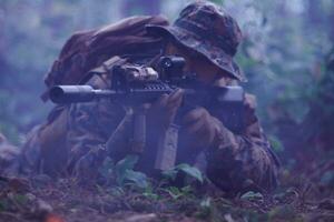 soldado em ação mirando na ótica de mira a laser de arma foto