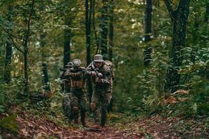 uma grupo do moderno guerra soldados é brigando uma guerra dentro perigoso controlo remoto floresta áreas. uma grupo do soldados é brigando em a inimigo linha com moderno armas. a conceito do guerra e militares conflitos foto