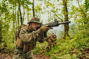 uma grupo do moderno guerra soldados é brigando uma guerra dentro perigoso controlo remoto floresta áreas. uma grupo do soldados é brigando em a inimigo linha com moderno armas. a conceito do guerra e militares conflitos foto