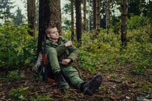 terrorista ter uma pausa e fumaça cigarro dentro floresta durante batalha foto