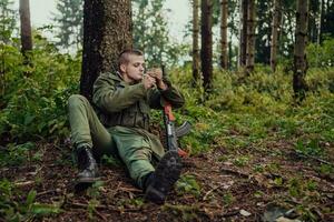 terrorista ter uma pausa e fumaça cigarro dentro floresta durante batalha foto