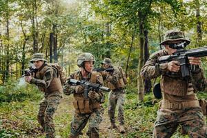 uma grupo do moderno guerra soldados é brigando uma guerra dentro perigoso controlo remoto floresta áreas. uma grupo do soldados é brigando em a inimigo linha com moderno armas. a conceito do guerra e militares conflitos foto