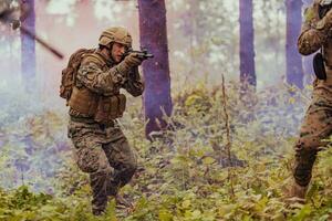 uma grupo do moderno guerra soldados é brigando uma guerra dentro perigoso controlo remoto floresta áreas. uma grupo do soldados é brigando em a inimigo linha com moderno armas. a conceito do guerra e militares conflitos foto