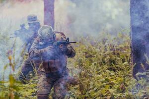 uma grupo do moderno guerra soldados é brigando uma guerra dentro perigoso controlo remoto floresta áreas. uma grupo do soldados é brigando em a inimigo linha com moderno armas. a conceito do guerra e militares conflitos foto