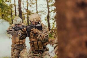 uma grupo do moderno guerra soldados é brigando uma guerra dentro perigoso controlo remoto floresta áreas. uma grupo do soldados é brigando em a inimigo linha com moderno armas. a conceito do guerra e militares conflitos foto