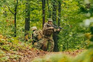 uma grupo do moderno guerra soldados é brigando uma guerra dentro perigoso controlo remoto floresta áreas. uma grupo do soldados é brigando em a inimigo linha com moderno armas. a conceito do guerra e militares conflitos foto