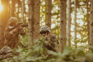 uma grupo do moderno guerra soldados é brigando uma guerra dentro perigoso controlo remoto floresta áreas. uma grupo do soldados é brigando em a inimigo linha com moderno armas. a conceito do guerra e militares conflitos foto