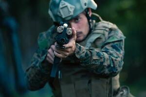 uma moderno guerra soldado em guerra dever dentro denso e perigoso floresta áreas. perigoso militares resgate operações foto