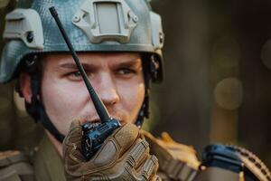 moderno guerra soldado comandante Policial falando portátil rádio estação e dar ordens subdivisão pelotão foto