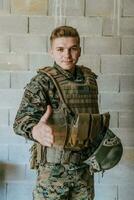 uma soldado dentro uniforme carrinhos dentro frente do uma pedra parede com a estendido mão. a conceito do militares e guerra parceria foto