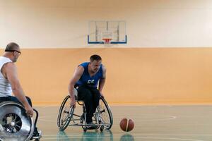 veteranos de guerra com deficiência em ação enquanto jogavam basquete em uma quadra de basquete com equipamentos esportivos profissionais para deficientes foto