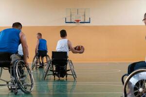 veteranos de guerra deficientes em cadeiras de rodas com equipamento profissional jogam basquete no salão. o conceito de esportes com deficiência foto