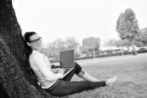 mulher com laptop no parque foto