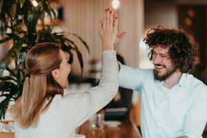 o negócio casal sentado dentro uma cafeteria depois de uma dia da semana foto