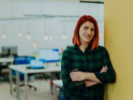 Tiros na Cabeça retrato do uma moderno mulher com cruzado braços dentro a escritório às noite de a janela foto