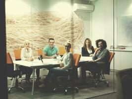 equipe de negócios de inicialização em uma reunião no prédio de escritórios à noite moderna foto