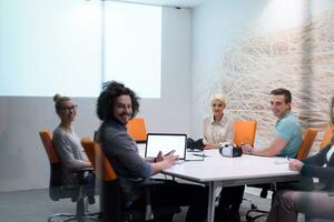 equipe de negócios de inicialização em uma reunião no prédio de escritórios à noite moderna foto