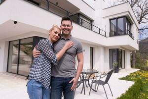 casal se abraçando em frente a nova casa de luxo foto