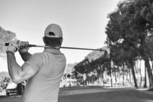 jogador de golfe batendo tiro com taco foto