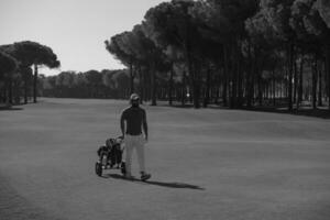 jogador de golfe andando com bolsa de rodas foto