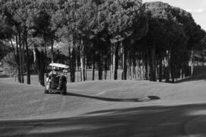 casal de buggy no campo de golfe foto