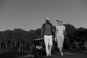 casal andando no campo de golfe foto