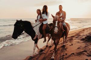 a família passa o tempo com seus filhos enquanto andam a cavalo juntos em uma praia de areia. foco seletivo foto