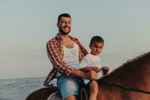 pai e filho gostam de andar a cavalo juntos à beira-mar. foco seletivo foto