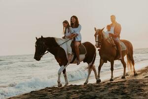 a família passa o tempo com seus filhos enquanto andam a cavalo juntos em uma praia de areia. foco seletivo foto