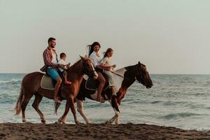 a família passa o tempo com seus filhos enquanto andam a cavalo juntos em uma praia de areia. foco seletivo foto