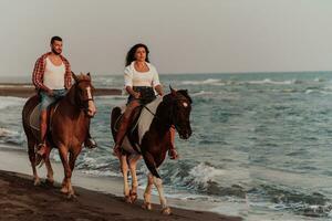 um casal apaixonado em roupas de verão, montando um cavalo em uma praia ao pôr do sol. mar e pôr do sol ao fundo. foco seletivo foto