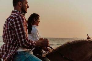 um casal apaixonado em roupas de verão, montando um cavalo em uma praia ao pôr do sol. mar e pôr do sol ao fundo. foco seletivo foto