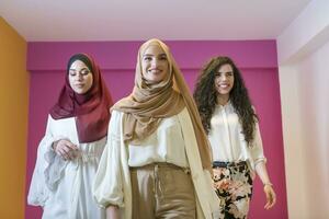 grupo retrato do lindo muçulmano mulheres dois do eles dentro uma elegante vestir com hijab isolado em uma Rosa fundo foto