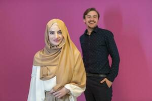 retrato de feliz jovem casal muçulmano dançando isolado no fundo rosa foto