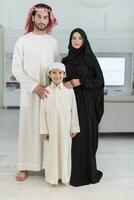 retrato do uma jovem feliz árabe muçulmano família casal com uma filho dentro tradicional roupas gastos Tempo juntos foto