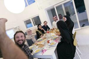 eid Mubarak muçulmano família tendo iftar jantar levando As fotos com Móvel telefone enquanto comendo tradicional Comida durante Ramadã festa mês às lar. a islâmico halal comendo e bebendo islâmico famil