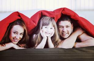 família feliz relaxando na cama foto