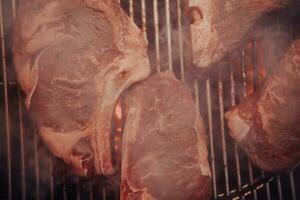 fechar-se foto do delicioso carne ser grelhado. dentro a fundo, amigos e família estão sentado e esperando para uma refeição