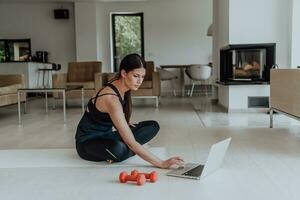 jovem lindo fêmea exercício, alongamento e praticando ioga com treinador através da vídeo ligar conferência dentro brilhante ensolarado loft apartamento. saudável estilo de vida, bem estar e atenção conceito. foto