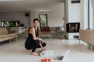 uma jovem mulher dentro Esportes roupas preparando Esportes equipamento para conectados Treinamento dentro dela vivo quarto foto