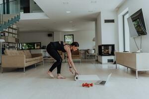 jovem lindo fêmea exercício, alongamento e praticando ioga com treinador através da vídeo ligar conferência dentro brilhante ensolarado loft apartamento. saudável estilo de vida, bem estar e atenção conceito. foto