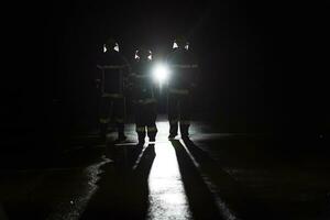 retrato do uma grupo do bombeiros em pé e caminhando bravo e otimista com uma fêmea Como equipe líder. foto