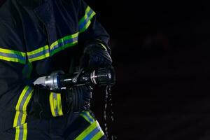 bombeiros usar uma água mangueira para eliminar uma fogo perigo. equipe do bombeiros dentro a perigoso resgate missão. foto