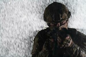 exército soldado dentro combate uniformes com a assalto rifle, prato transportadora e combate capacete indo em uma perigoso missão em uma chuvoso noite. foto